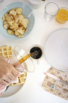 Hochformatiger Blick auf einen Frühstückstisch, Waffeln, Bratkartoffeln, Kaffee und Saft. - MINF03823