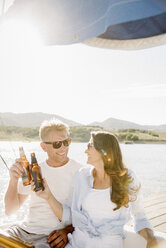 Mann und Frau auf einem Segelboot, die einen Drink zu sich nehmen. - MINF03868