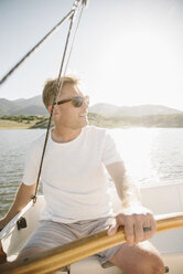 Portrait of a blond man with sunglasses steering a sail boat. - MINF03871