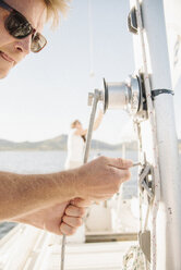 Porträt eines blonden Mannes mit Sonnenbrille auf einem Segelboot. - MINF03876