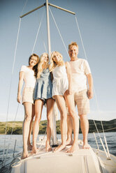 Mann, Frau und ihre beiden blonden Töchter auf einem Segelboot. - MINF03892
