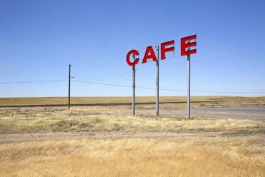 Große rote Großbuchstaben auf Metallstangen werben für ein Café in einer Prärie. - MINF03917