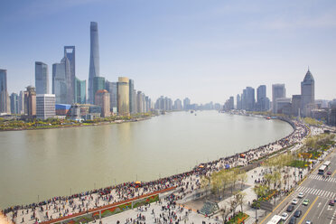 City skyline with tall skyscrapers across river, crowds on promenade. - MINF03926