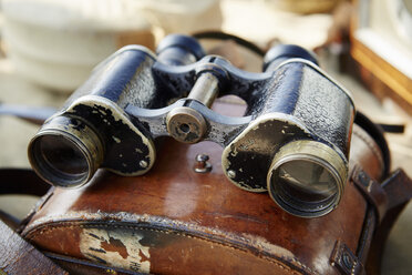 Pair of vintage binoculars with a worn leather case at a flea market. - MINF03960