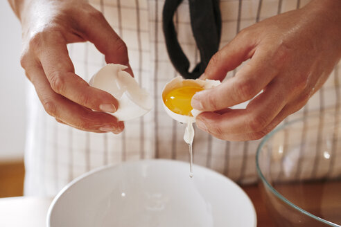 Woman's hands separating egg, close-up - BZF00442