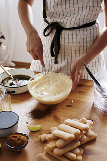 Woman stirring Mascarpone cream for preparing Tiramisu, partial view - BZF00445