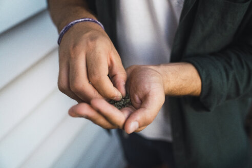 Junger Mann mit Cannabis in der Hand - KKAF01331