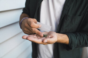 Junger Mann mit Cannabis in der Hand - KKAF01334