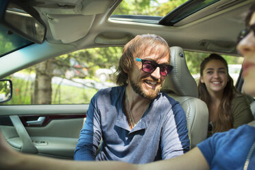 A group of people inside a car, on a road trip. A driver and two passengers. - MINF04069