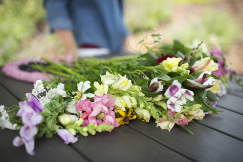 Ein Strauß Sommergartenblumen auf einem Tisch im Freien. - MINF04085