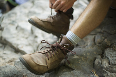 Ein Mann zieht seine Stiefel aus - MINF04091