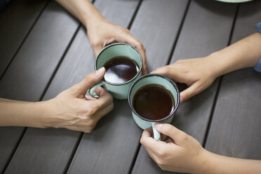 Zwei Personen an einem Tisch sitzend, Kaffee trinkend, von oben gesehen. - MINF04102