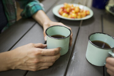 Zwei Personen an einem Tisch sitzend, Kaffee trinkend, von oben gesehen. - MINF04103