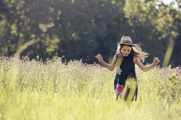 Ein Kind, ein junges Mädchen mit Strohhut auf einer Wildblumenwiese im Sommer. - MINF04165