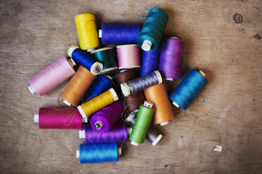 Bobbins of wound thread, silks and cottons in bright colours. - MINF04188
