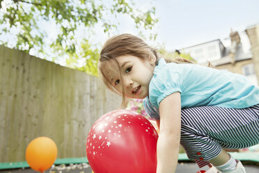 Young girl playing in garden with balloons - ISF19616