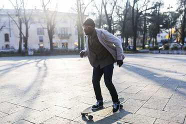 Junger Mann auf dem Skateboard auf einem städtischen Platz - GIOF04062