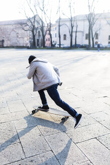 Junger Mann auf dem Skateboard auf einem städtischen Platz - GIOF04065