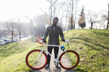 Junge hält Fahrrad im Park - GIOF04076