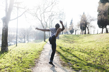 Junger Mann trainiert Kickboxen im Park - GIOF04077