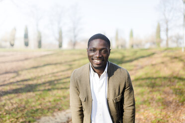 Portrait ogf young man in park, wearing jacket, smiling - GIOF04081