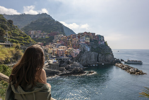 Italy, Liguria, La Spezia, Cinque Terre National Park, young woman looking to Manarola - RPSF00213