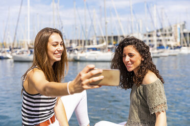 Zwei glückliche Freundinnen machen ein Selfie in einem Yachthafen - WPEF00755