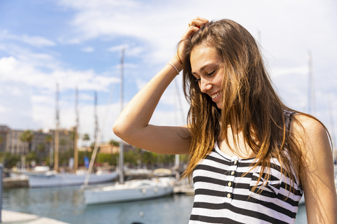 Lächelnde junge Frau in einem Jachthafen, lizenzfreies Stockfoto