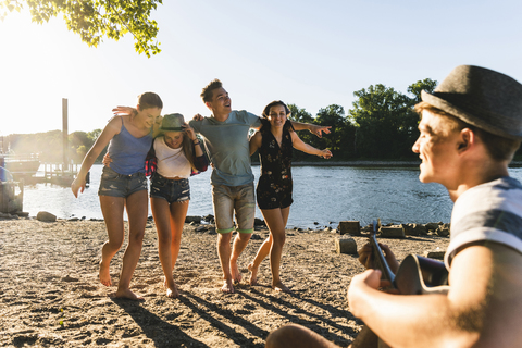 Eine Gruppe von Freunden feiert eine Party am Flussufer, lizenzfreies Stockfoto