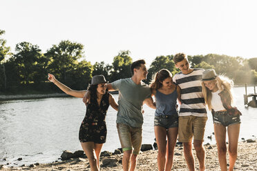 Group of happy friends arm in arm at the riverside - UUF14798