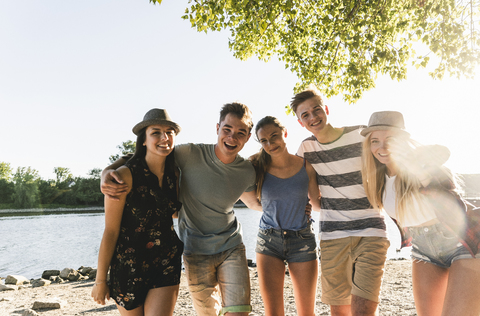 Portrait of group of happy friends arm in arm at the riverside stock photo