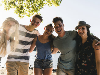 Portrait of group of happy friends arm in arm at the riverside - UUF14802