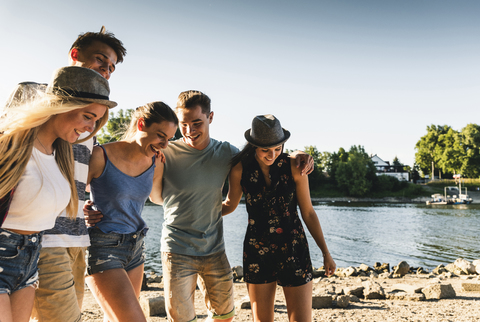 Group of happy friends arm in arm at the riverside stock photo