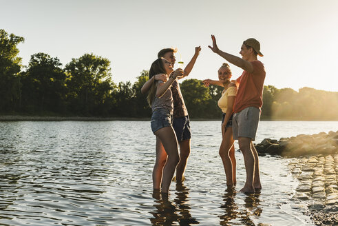 Gruppe von glücklichen Freunden in einem Fluss bei Sonnenuntergang - UUF14816