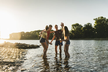 Group of happy friends in a river at sunset - UUF14817