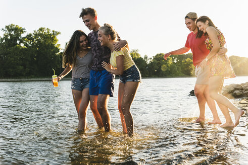 Group of happy friends in a river at sunset - UUF14819