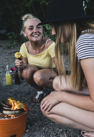 Zwei glückliche junge Frauen beim Grillen, lizenzfreies Stockfoto