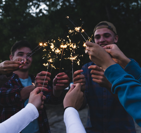 Gruppe von Freunden mit Wunderkerzen am Abend, lizenzfreies Stockfoto