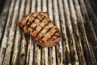 Close up high angle view of a steak on a griddle. - MINF04402