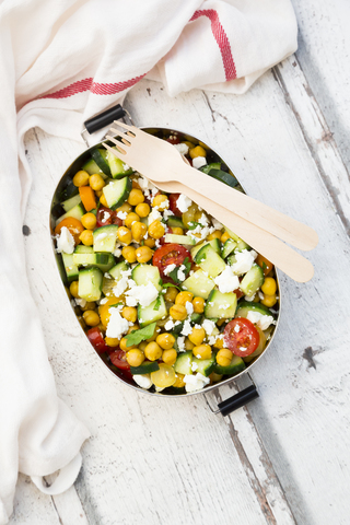 Lunch box of salad with chick peas roasted with curcuma, feta, cucumber, tomatoes and parsley stock photo