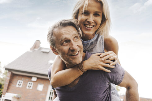 Happy mature couple in front of their home - JOSF02526