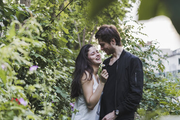Glückliches junges Paar im Gebüsch stehend - AFVF01235