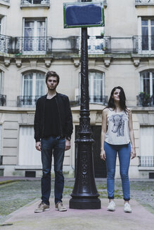 Frankreich, Paris, junges Paar steht an einem Laternenpfahl vor einem städtischen Gebäude - AFVF01238