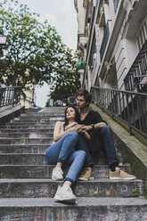 France, Paris, young couple sitting on stairs in the district Montmartre - AFVF01243