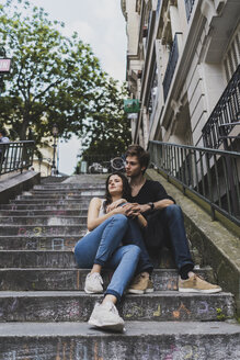 Frankreich, Paris, junges Paar sitzt auf einer Treppe im Stadtteil Montmartre - AFVF01243