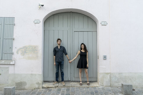 Junges Paar steht Hand in Hand vor einem Gebäude - AFVF01260