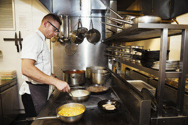 Chef cooking in a restaurant kitchen. - MINF04660