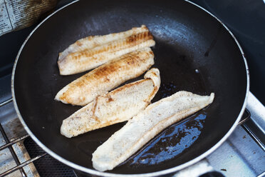 Close up of fish fillets being fried in a frying pan. - MINF04685