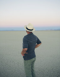 Mann mittleren Alters, der das Spiel in der Morgendämmerung betrachtet, Black Rock Desert, Nevada - MINF04758