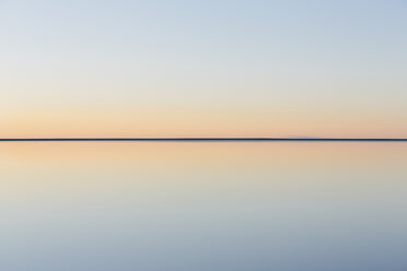 Der Blick auf die klare Linie des Horizonts, wo das Land auf den Himmel trifft, über die überschwemmte Oberfläche der Bonneville Salt Flats. Dämmerlicht, - MINF04766